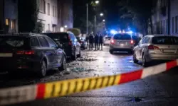Abgesperrte Wohnstraße in Köln-Porz bei Nacht mit beschädigten Autos und Blaulicht nach einer Explosion und Polizeieinsatz.