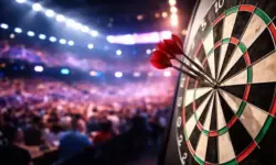 Dartscheibe mit mehreren Pfeilen in einer beleuchteten Arena während eines Spiels der Darts-Weltmeisterschaft