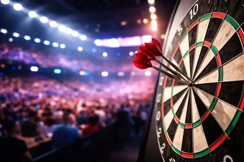 Dartscheibe mit mehreren Pfeilen in einer beleuchteten Arena während eines Spiels der Darts-Weltmeisterschaft