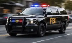 Schwarzes FBI-SUV mit eingeschaltetem Blaulicht fährt durch eine städtische Straße, Einsatzfahrzeug der US-Bundespolizei in Bewegung.