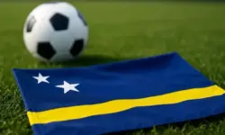 Ein unmarkierter Fußball liegt auf einem frisch gemähten Rasen in einem hell ausgeleuchteten Stadion, ohne Menschen oder sichtbare Beschriftungen.