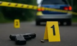 Polizeiband im Vordergrund, dahinter unscharfe Blaulichter eines Einsatzfahrzeugs in einer nächtlichen Straßenszene.