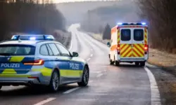 Polizeiauto und Krankenwagen stehen mit eingeschaltetem Blaulicht auf einer Landstraße in Bayern, umgeben von winterlicher Landschaft