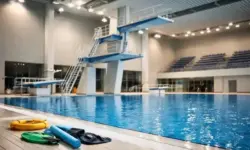 Leerer Sprungturm über einem Schwimmbecken in einer Hallenbadanlage während eines Turmspring-Wettbewerbs
