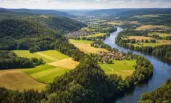 Weitläufige bayerische Landschaft mit Hügeln, Fluss und offenen Feldern, aufgenommen aus erhöhter Perspektive bei klarem Tageslicht.