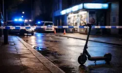 Nächtliche Straße in der Dortmunder Nordstadt mit abgesperrtem Kiosk, Polizeilicht und abgestelltem E-Roller am Fahrbahnrand.