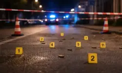 Abgesperrte Straße in Dortmund bei Nacht mit Markierungen auf dem Asphalt und Blaulichtreflexionen nach einer Schusswaffentat.