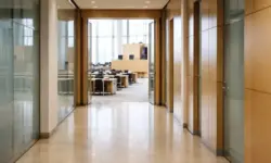 Leerer Flur eines Landtagsgebäudes mit Blick auf einen geöffneten Plenarsaal, moderne Architektur, sachliche Innenaufnahme.