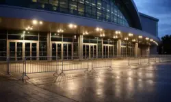 Leerer Vorplatz vor einer großen Veranstaltungshalle am Abend mit geschlossenen Eingängen und Beleuchtung, ohne Menschen oder Beschriftungen