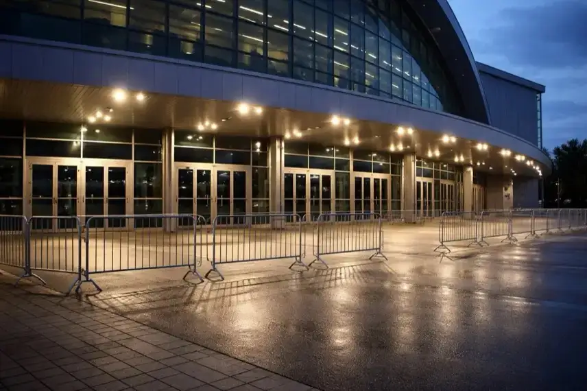 Leerer Vorplatz vor einer großen Veranstaltungshalle am Abend mit geschlossenen Eingängen und Beleuchtung, ohne Menschen oder Beschriftungen