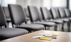 Leere Stühle in einem neutralen Raum, davor mehrere unbeschriftete Karten auf einem Tisch, sachliche Lichtstimmung, Symbol für ADAC Austritte