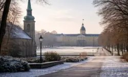 Winterliche Stadtansicht von Karlsruhe mit Schlossgarten, kahlen Bäumen und Kirche am Dreikönigstag, ruhige Feiertagsstimmung ohne Menschen.