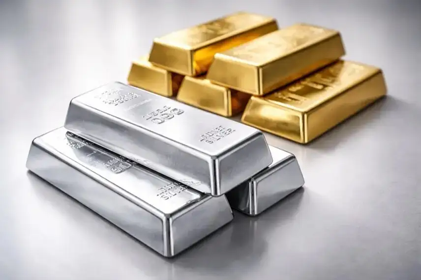 Silber- und Goldbarren liegen nebeneinander auf neutralem Untergrund, Silber im Vordergrund, Gold im Hintergrund, sachlich ausgeleuchtet.