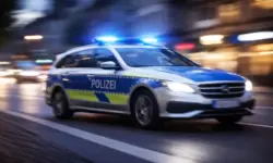 Fahrender Polizeiwagen mit eingeschaltetem Blaulicht in Göppingen bei Nacht, Bewegungsunschärfe auf Straße und Umgebung