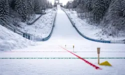 Leere Skisprungschanze im Winter mit sichtbaren Markierungen und Kontrolllinien im Schnee bei Tageslicht