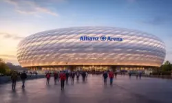 Außenansicht der Allianz Arena in München bei Abenddämmerung mit beleuchteter Stadionfassade und Vorplatz