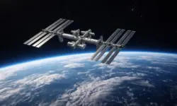 Internationale Raumstation ISS im Erdorbit über der Erde, sichtbar vor schwarzem Weltraum mit Wolkenformationen.