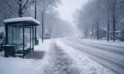 Verschneite Straße in Braunschweig mit glatter Fahrbahn, winterlichem Himmel und leerer Bushaltestelle bei starkem Schneefall.