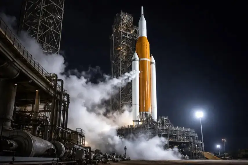 Schwerlastrakete auf Startrampe bei Nacht, Wasserdampf aus Betankungssystem, Vorbereitung auf Artemis-II-Test