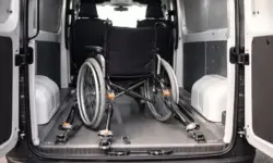 Gesicherter Rollstuhl im Laderaum eines Kleintransporters mit Gurtsystem und geschlossenen Hecktüren