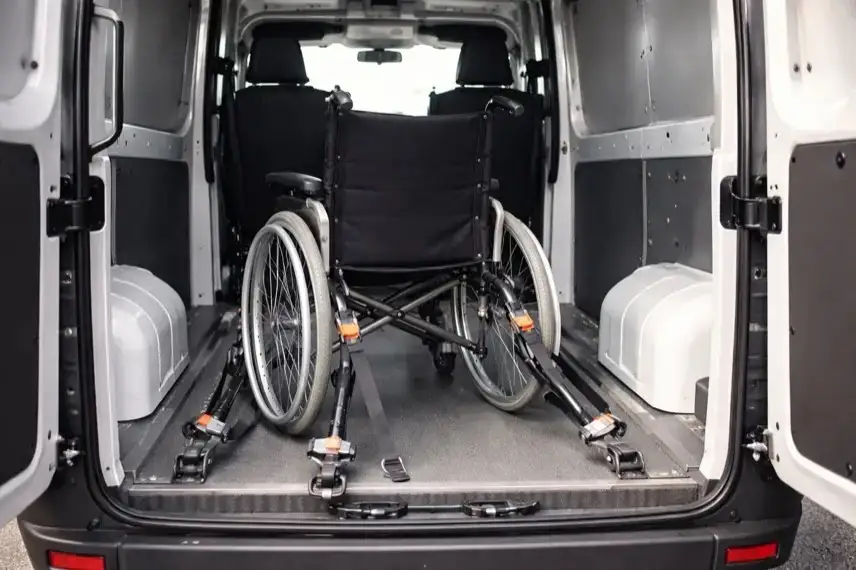 Gesicherter Rollstuhl im Laderaum eines Kleintransporters mit Gurtsystem und geschlossenen Hecktüren