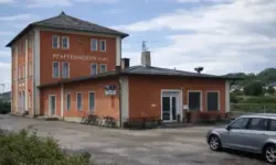 Leerer Bahnhof Pfaffenhofen bei Nacht mit Bahnsteig und Fahrradständern im künstlichen Licht