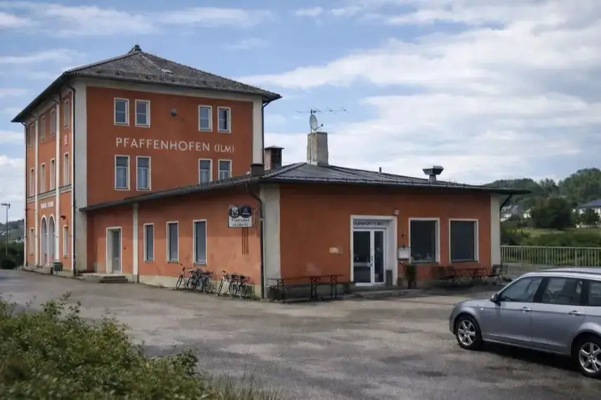 Leerer Bahnhof Pfaffenhofen bei Nacht mit Bahnsteig und Fahrradständern im künstlichen Licht