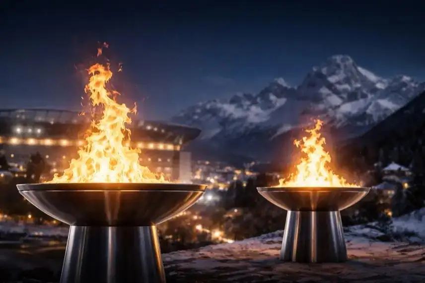 Zwei olympische Feuerschalen brennen nachts, eine vor städtischer Kulisse, eine vor alpinen Bergen, als Symbol für die Winterspiele 2026.