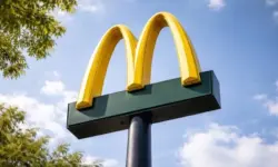 Abgesperrter Eingangsbereich eines Schnellrestaurants mit Einsatzfahrzeugen von Polizei und Feuerwehr im Hintergrund.