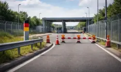 Leerer Grenzbereich mit Straße, Leitplanken und Absperrelementen bei Tageslicht, neutraler Kontrollraum für Grenzschutz und Migration