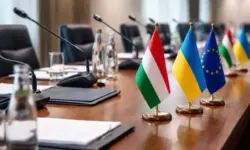 Konferenztisch mit Flaggen und Mikrofonen bei politischem Treffen, Symbol für Konflikt zwischen Ungarn, Ukraine und EU