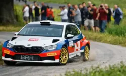Beschädigtes Rallyeauto nach Unfall in steilem Gelände neben Bergstraße, Rettungshubschrauber und Einsatzkräfte bei Rallye in Österreich
