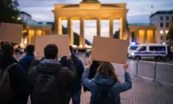 Demonstration in Berlin vor Wahrzeichen mit Menschen und Plakaten bei Protest gegen Krieg im Nahen Osten