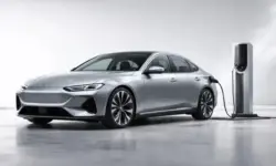 Moderne elektrische Limousine an Ladestation, futuristisches Auto mit aerodynamischem Design, Elektroauto Mittelklasse Reichweite 900 km