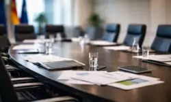 Leerer Konferenzraum mit Tisch, Stühlen und Dokumenten als Symbol für politische Konflikte in der Energiepolitik unter Kanzler Merz