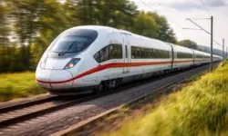 Zug am Bahnhof neben Tankstelle mit Autos zeigt Zusammenhang zwischen hohen Spritpreisen und Bahnverkehr in Deutschland